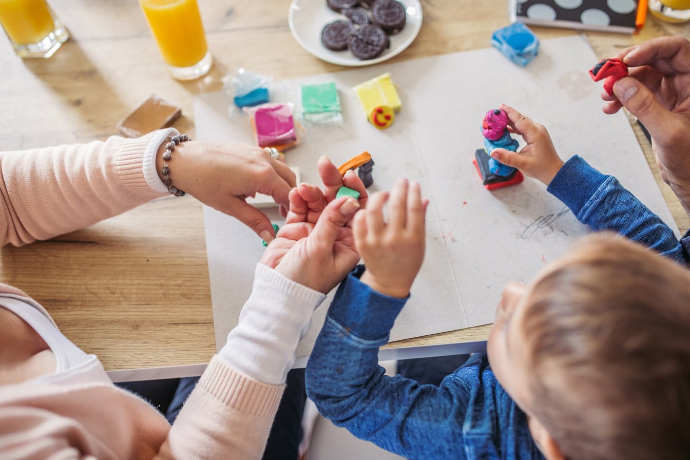 Parents And Little Son Playing with Child's Play Clay